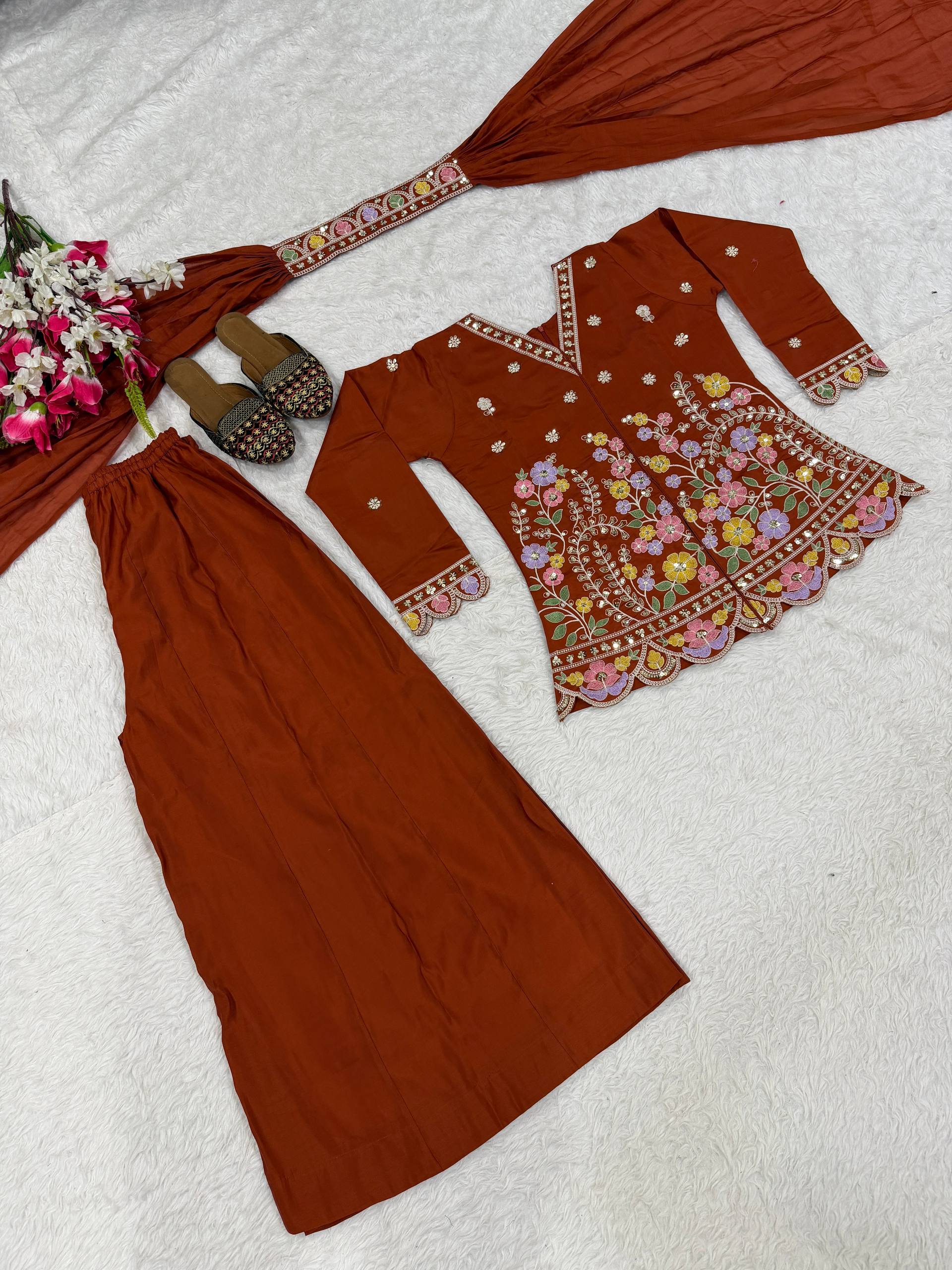 Resplendent Rust Orange Peplum Kurti and Flared Palazzo Suit Set Adorned with Intricate Multicolored Floral Embroidery, Sequin Accents, and Ornate Scalloped Borders